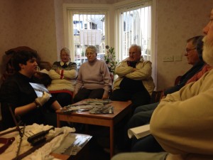 Charlie shows the group some photos and artefacts from the collection